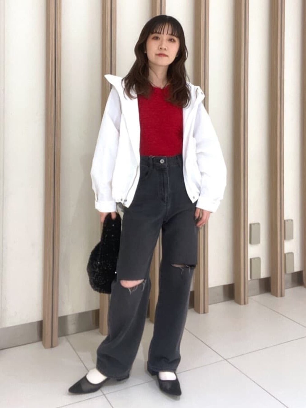 ホワイト系のマウンテンパーカー、レッド系のニット/セーター、ブラック系のパンプスを着用したレディースの春コーディネートの4枚目の写真