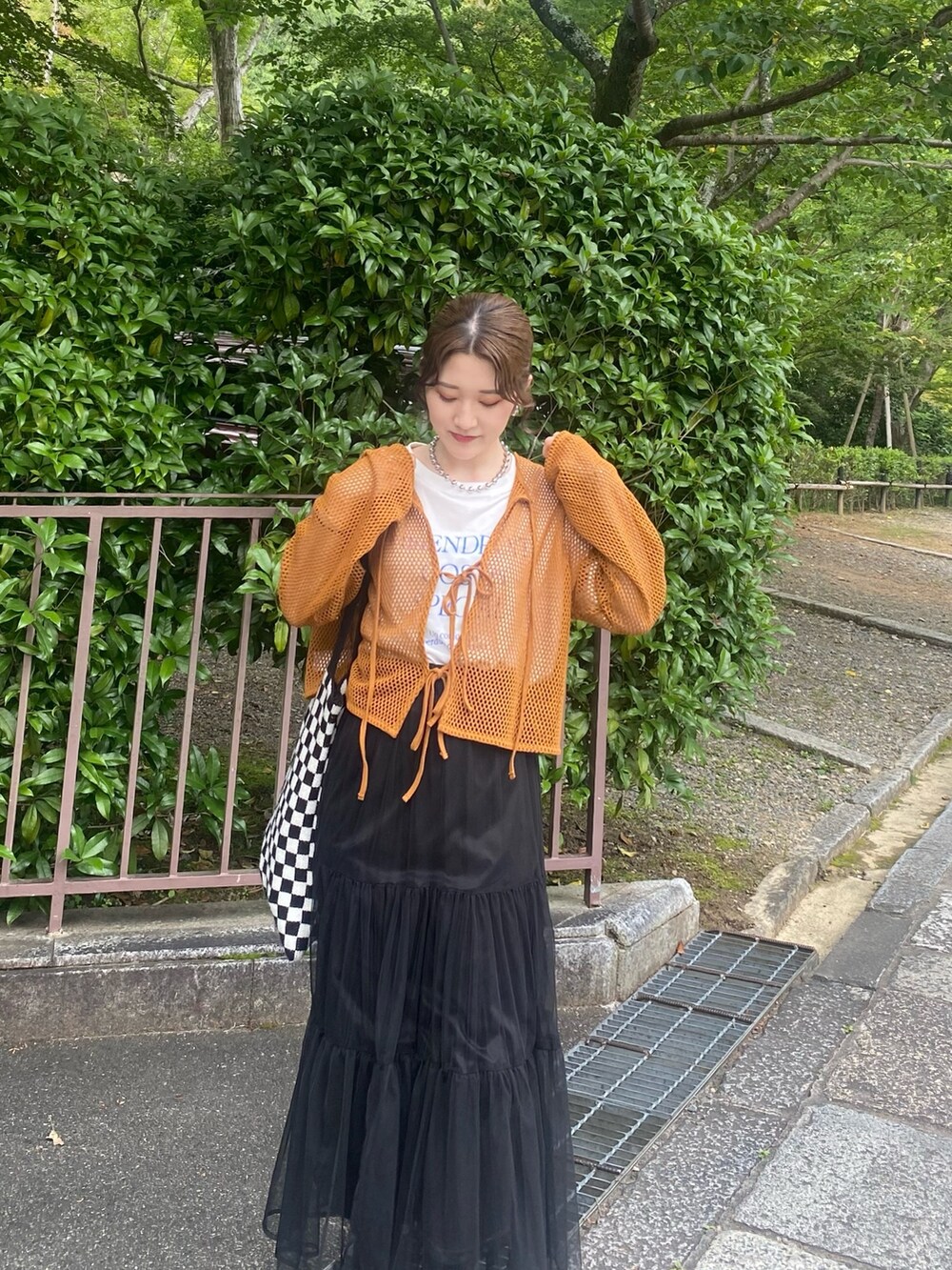 ブラウン系のTシャツ/カットソー、ブラック系のスカート、シルバー系のネックレスを着用したレディースの夏コーディネートの2枚目の写真