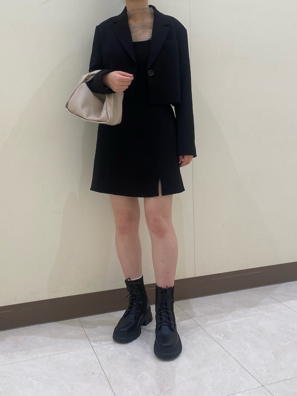 ブラック系のテーラードジャケット、ブラック系のワンピース、ベージュ系のTシャツ/カットソーを着用したレディースの秋コーディネートの3枚目の写真