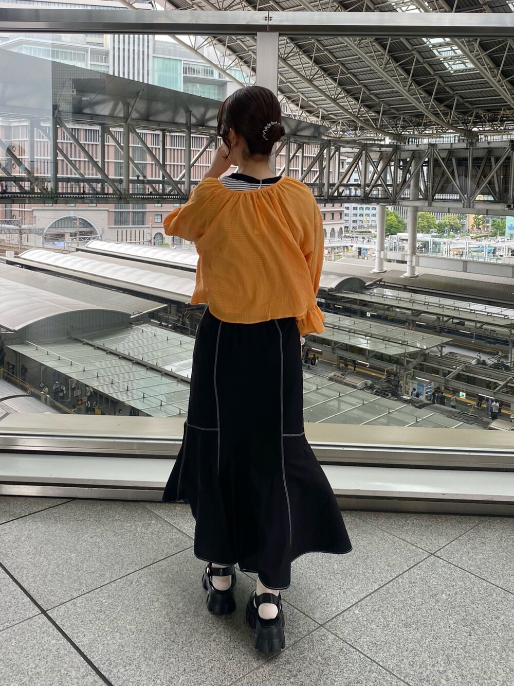 オレンジ系のシャツ/ブラウス、ブラック系のTシャツ/カットソー、ブラック系のスカートを着用したレディースの夏コーディネートの3枚目の写真