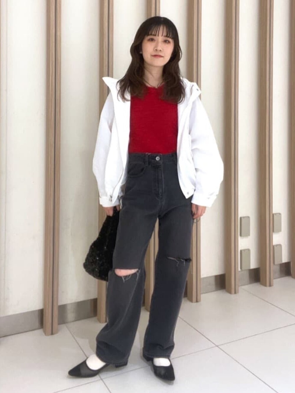 ホワイト系のマウンテンパーカー、レッド系のニット/セーター、ブラック系のパンプスを着用したレディースの春コーディネートの3枚目の写真