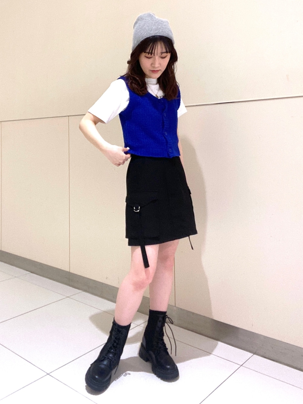 ブルー系のベスト、ホワイト系のTシャツ/カットソー、ブラック系のスカートを着用したレディースの春コーディネートの3枚目の写真