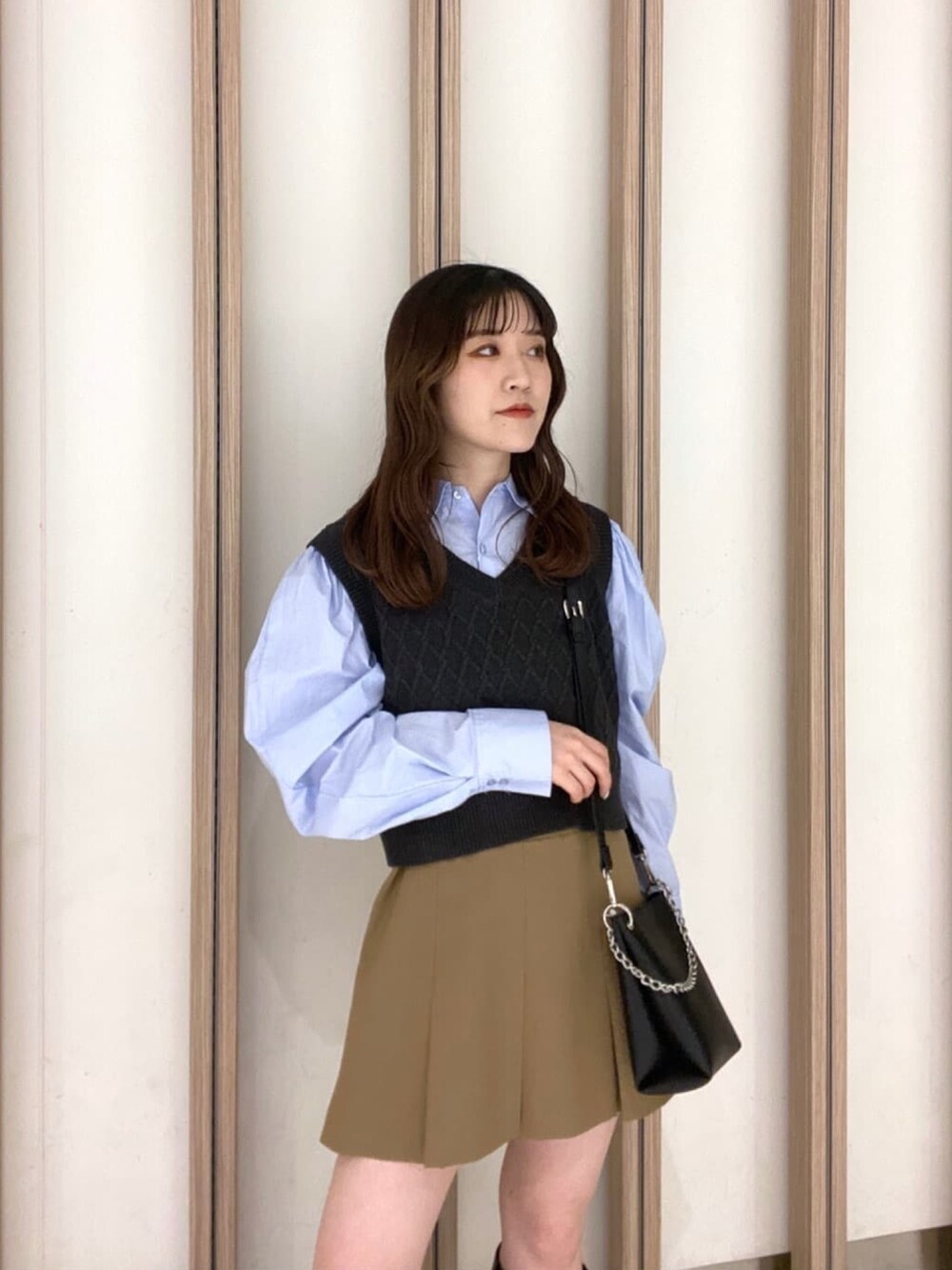 ブルー系のシャツ/ブラウス、ベージュ系のスカート、ブラック系のブーツを着用したレディースの冬コーディネートの6枚目の写真