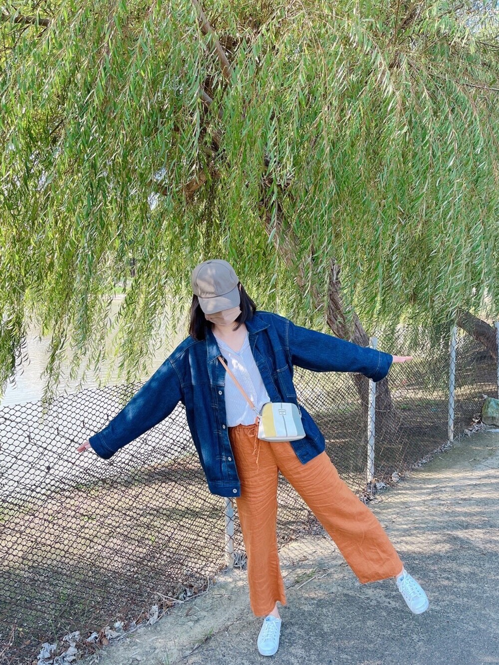 ブルー系のデニムジャケット、ホワイト系のTシャツ/カットソー、オレンジ系のその他パンツを着用したレディースの冬コーディネートの2枚目の写真