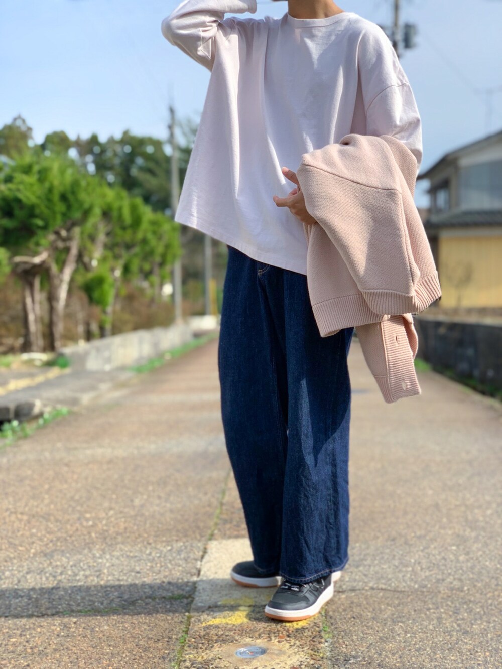 ベージュ系のカーディガン/ボレロ、ブルー系のパンツ、ブラック系のスニーカーを着用したメンズの春コーディネートの2枚目の写真