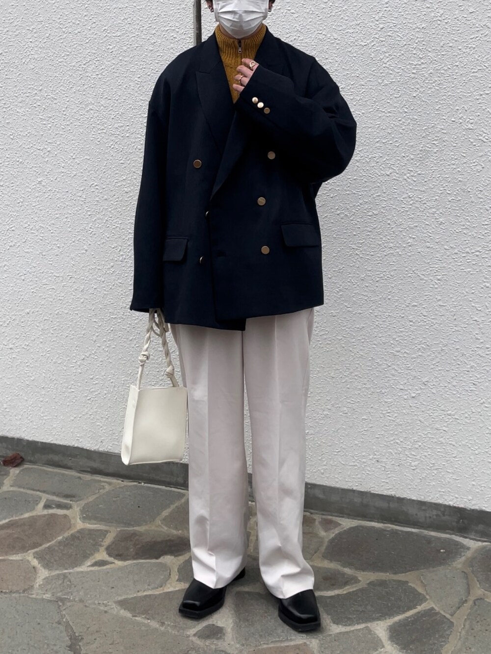 ブルー系のテーラードジャケット、ホワイト系のスラックス、ブラック系のブーツを着用したメンズの秋コーディネートの2枚目の写真