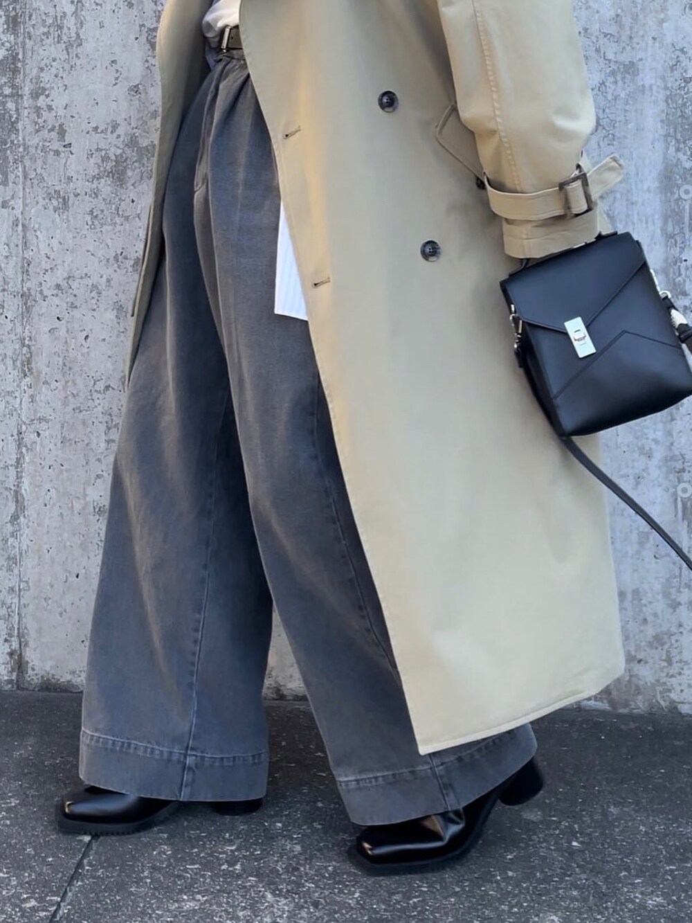 グレー系のデニムパンツ、ブラック系のブーツ、ブラック系のショルダーバッグを着用したメンズの秋コーディネートの4枚目の写真