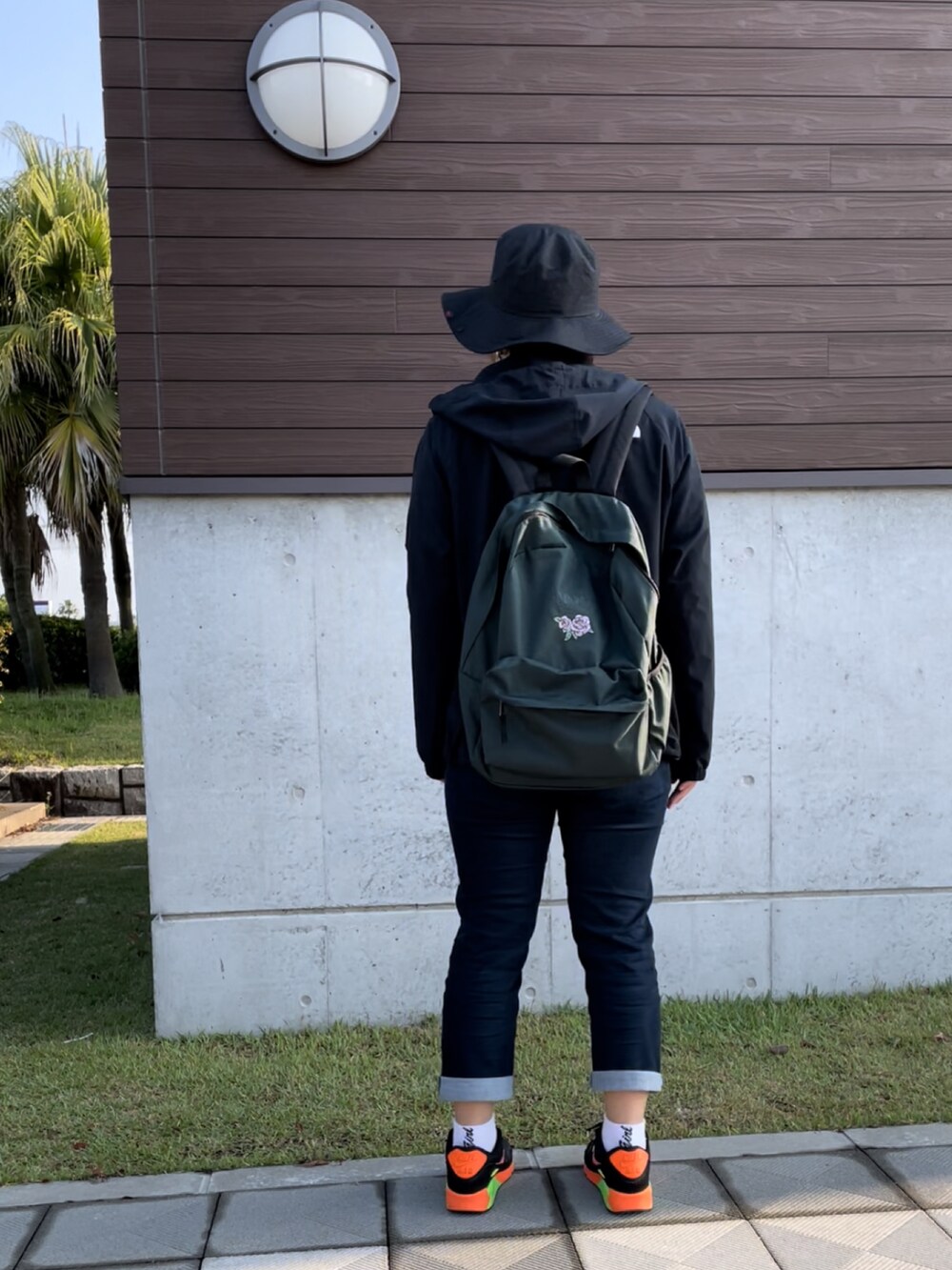 ブルー系のデニムパンツ、ブラック系のスニーカー、ホワイト系のTシャツ/カットソーを着用したレディースの春コーディネートの3枚目の写真