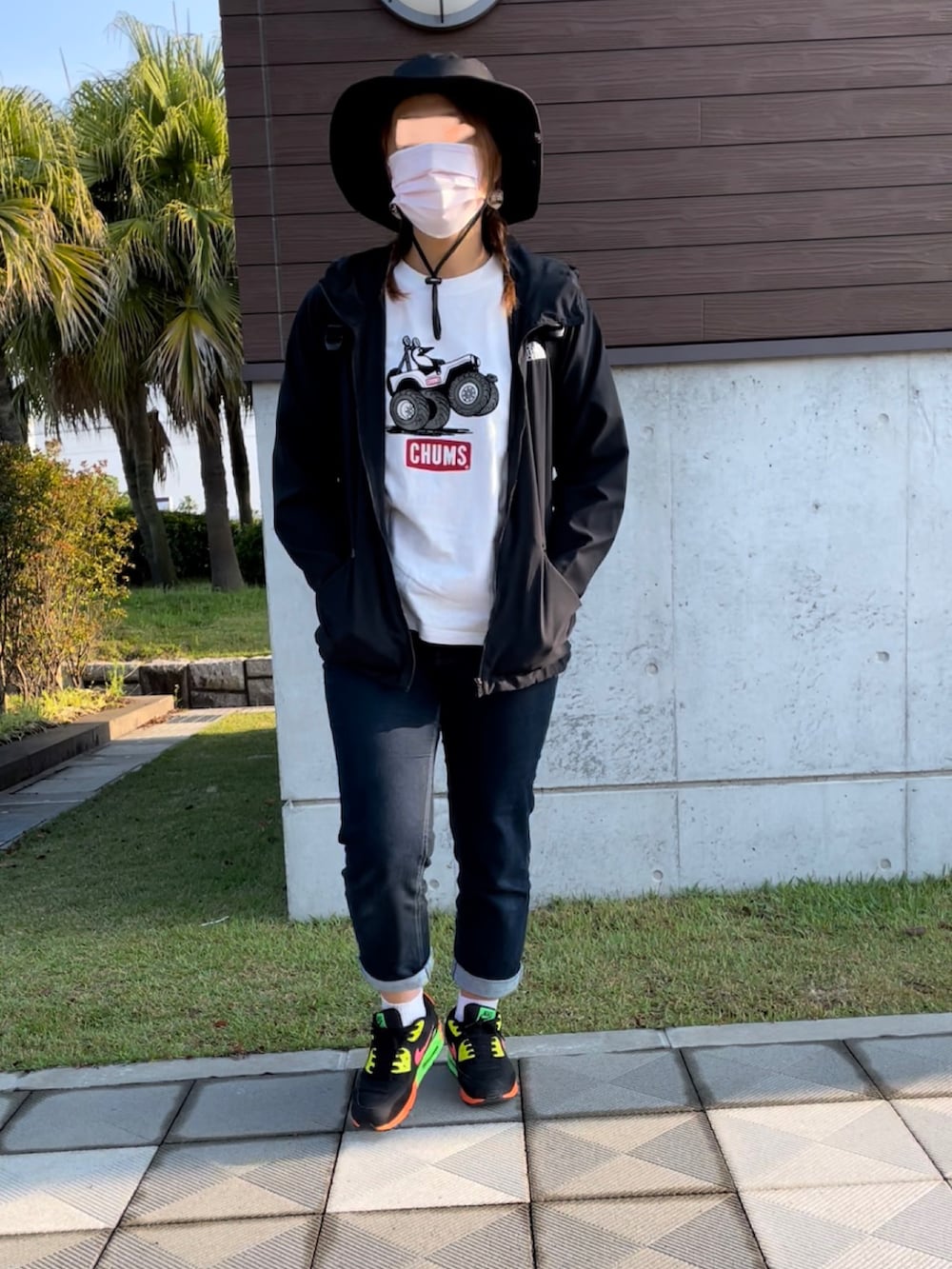 ブルー系のデニムパンツ、ブラック系のスニーカー、ホワイト系のTシャツ/カットソーを着用したレディースの春コーディネートの2枚目の写真