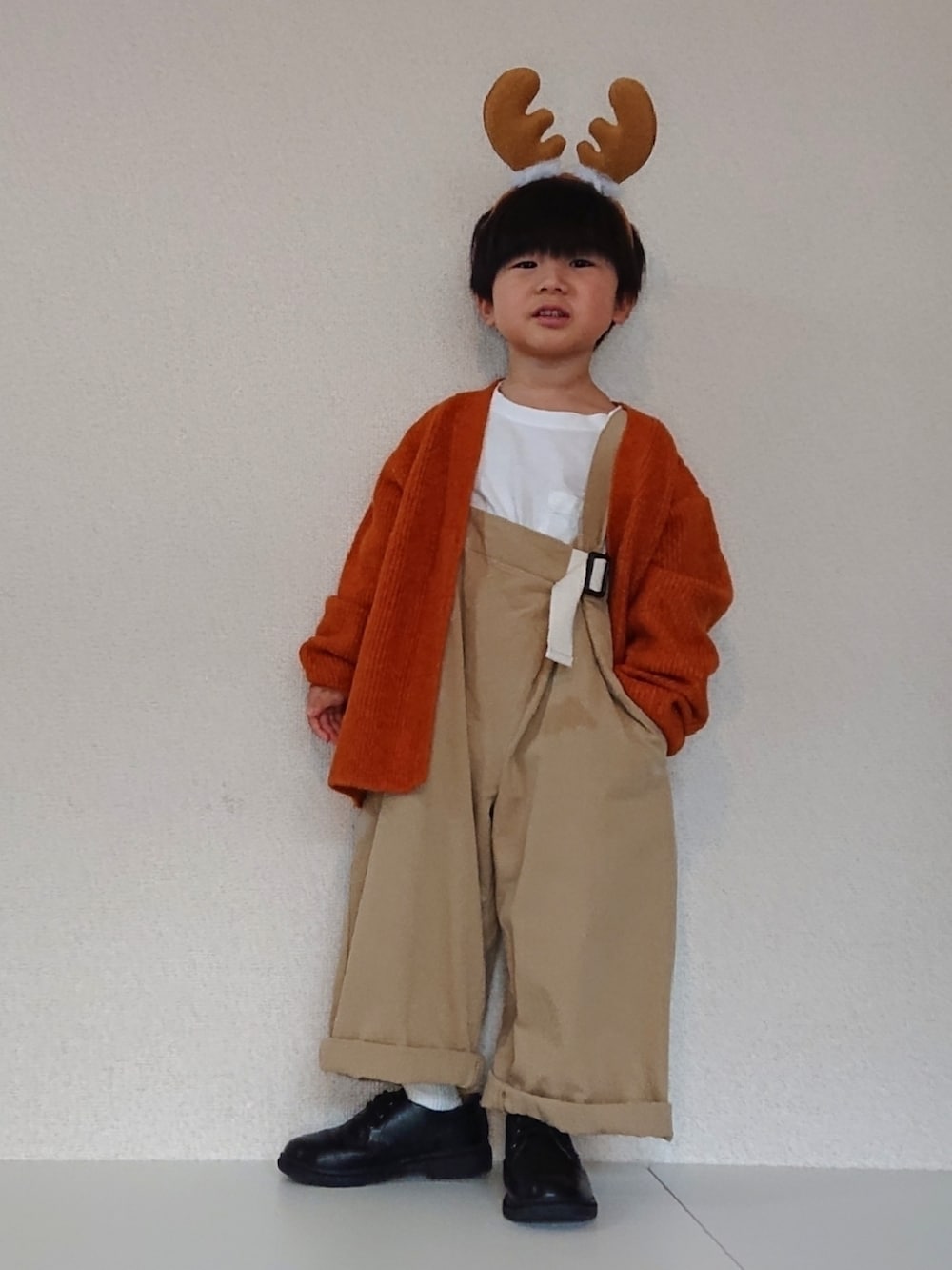 オレンジ系のカーディガン/ボレロ、ベージュ系のサロペット/オーバーオール、ホワイト系のTシャツ/カットソーを着用したキッズの冬コーディネートの5枚目の写真