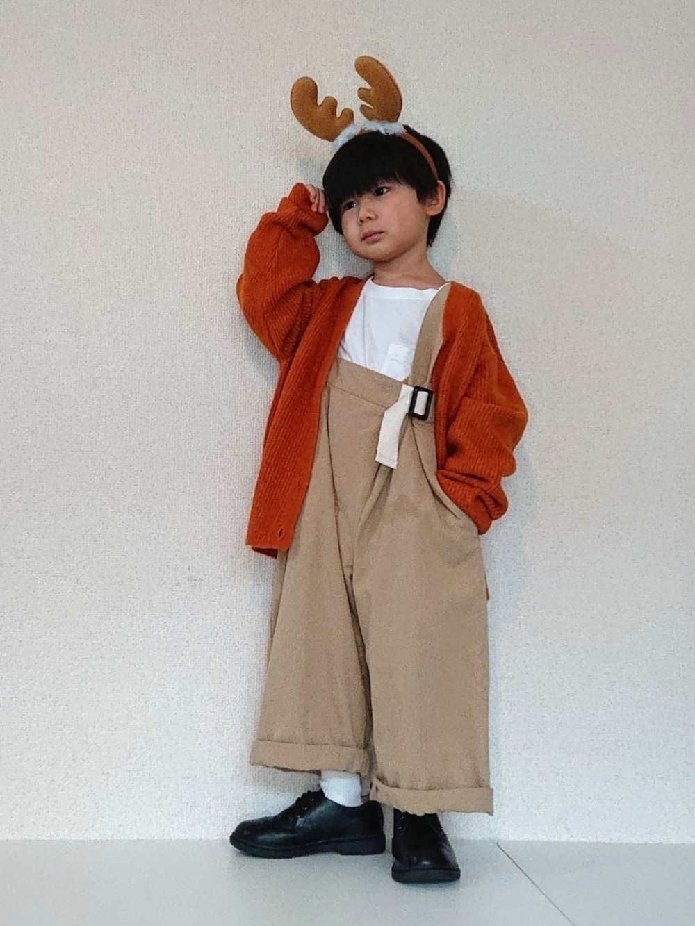 オレンジ系のカーディガン/ボレロ、ベージュ系のサロペット/オーバーオール、ホワイト系のTシャツ/カットソーを着用したキッズの冬コーディネートの2枚目の写真