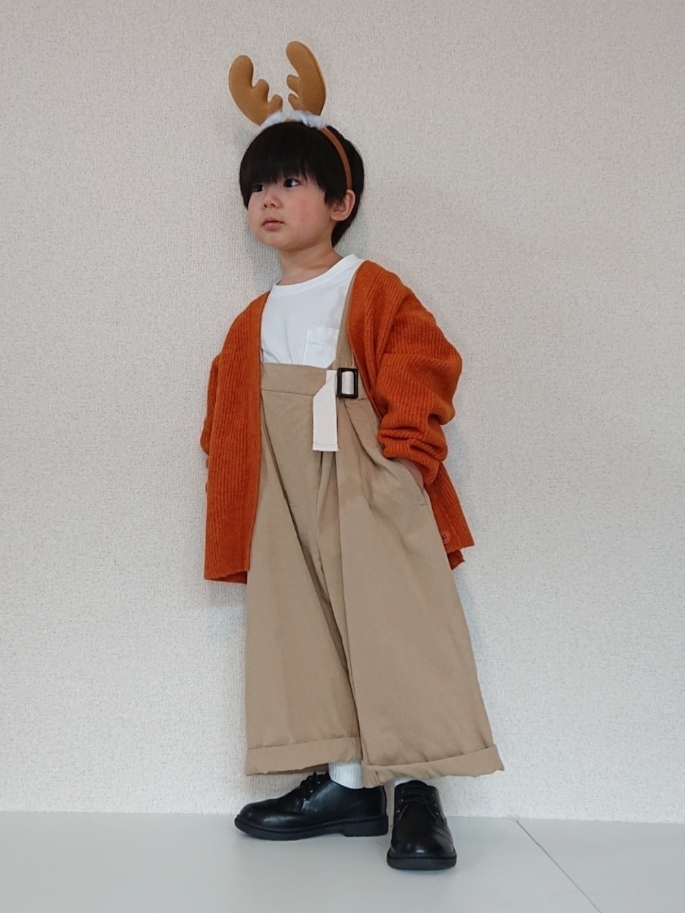 オレンジ系のカーディガン/ボレロ、ベージュ系のサロペット/オーバーオール、ホワイト系のTシャツ/カットソーを着用したキッズの冬コーディネートの4枚目の写真