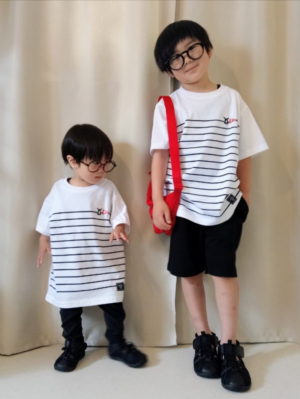 ホワイト系のTシャツ/カットソー、ブラック系のタンクトップ、ブラック系のスウェットパンツを着用したキッズの夏コーディネートの2枚目の写真