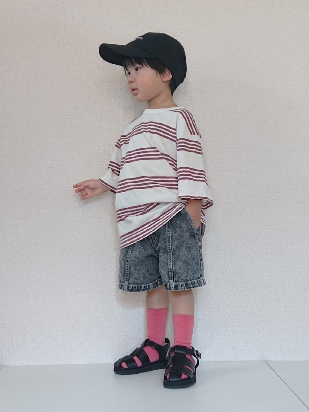 ホワイト系のTシャツ/カットソー、ブラック系のデニムパンツ、ブラック系のサンダルを着用したキッズの夏コーディネートの4枚目の写真