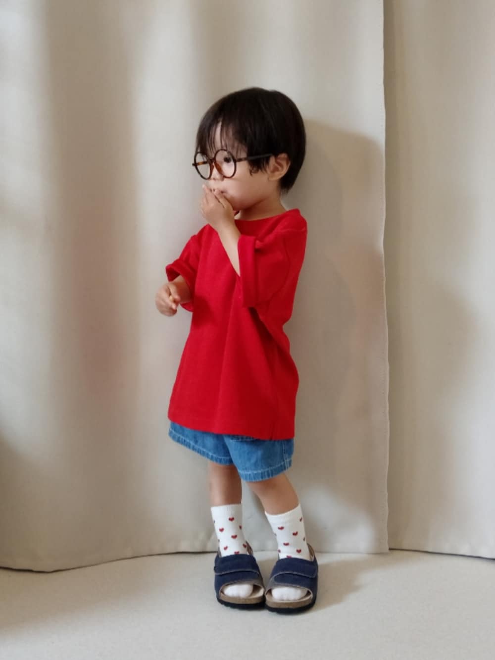 レッド系のTシャツ/カットソー、ブルー系のパンツ、ブルー系のサンダルを着用したキッズの夏コーディネートの2枚目の写真