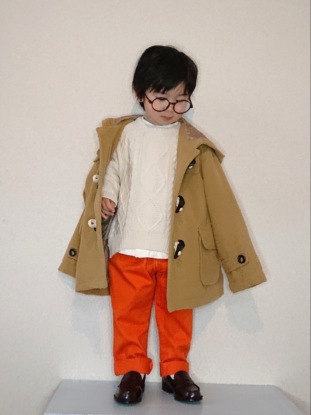 ホワイト系のニット/セーター、ホワイト系のシャツ/ブラウス、ベージュ系のダッフルコートを着用したキッズの冬コーディネートの2枚目の写真