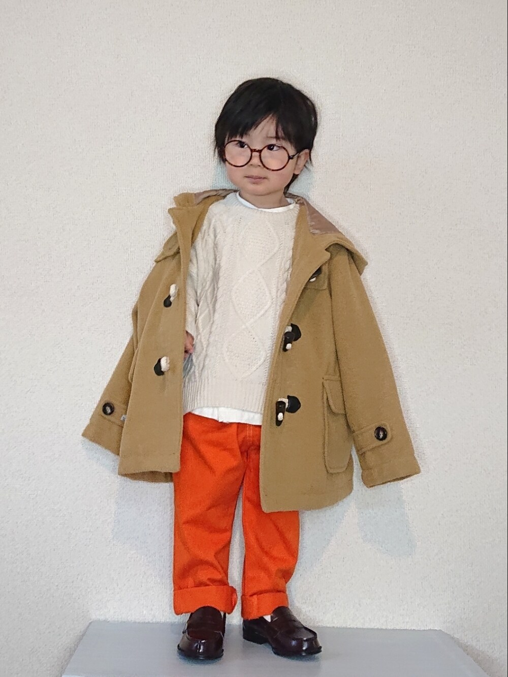 ホワイト系のニット/セーター、ホワイト系のシャツ/ブラウス、ベージュ系のダッフルコートを着用したキッズの冬コーディネートの3枚目の写真