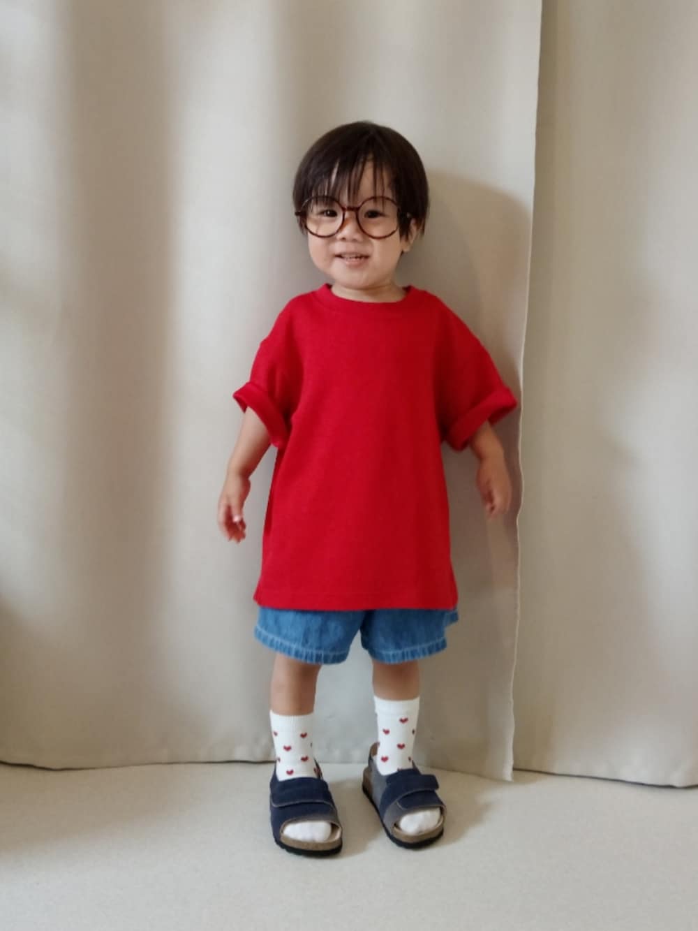 レッド系のTシャツ/カットソー、ブルー系のパンツ、ブルー系のサンダルを着用したキッズの夏コーディネートの3枚目の写真