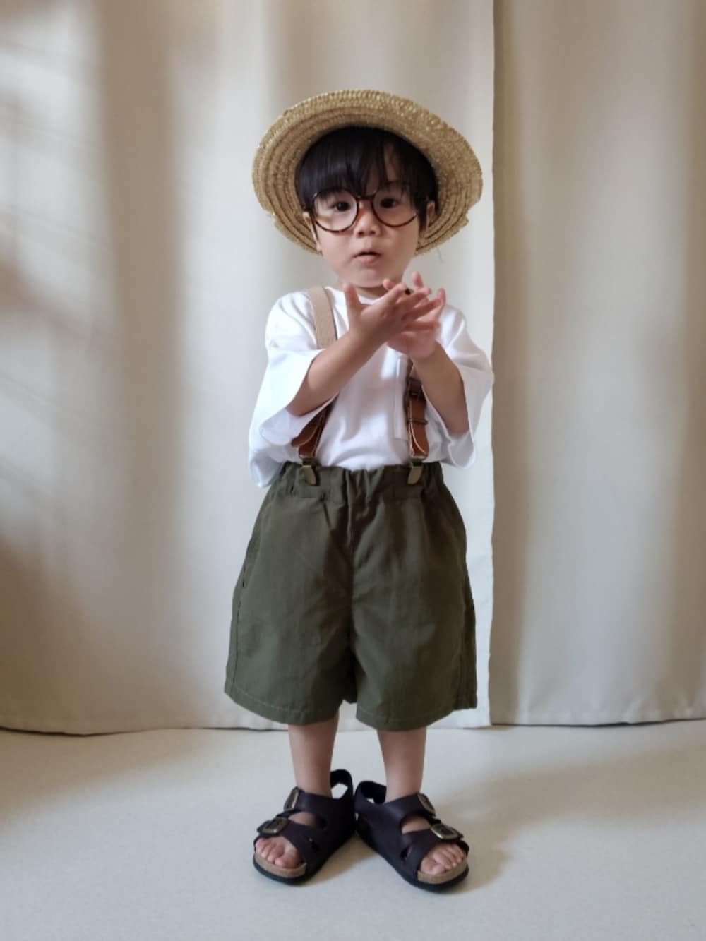 ホワイト系のTシャツ/カットソー、グリーン系のパンツ、ブラウン系のサンダルを着用したキッズの夏コーディネートの2枚目の写真