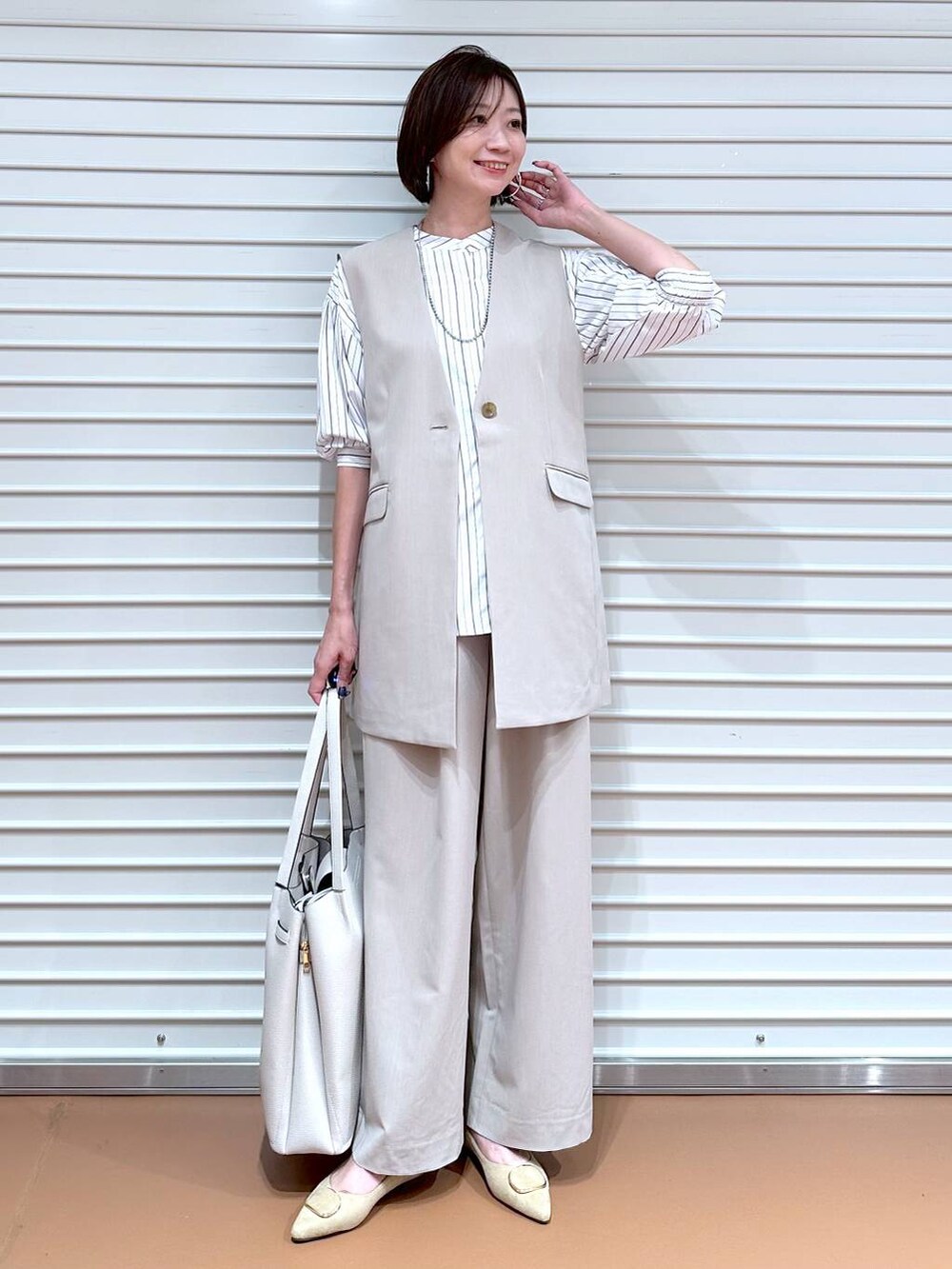 ブラック系のシャツ/ブラウス、ベージュ系のその他パンツ、ベージュ系のベストを着用したレディースの秋コーディネートの2枚目の写真