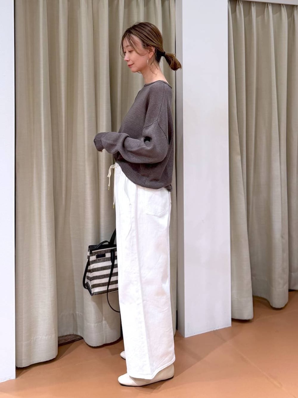 ホワイト系のパンプス、ホワイト系のデニムパンツ、ブラック系のトートバッグを着用したレディースの春コーディネートの3枚目の写真