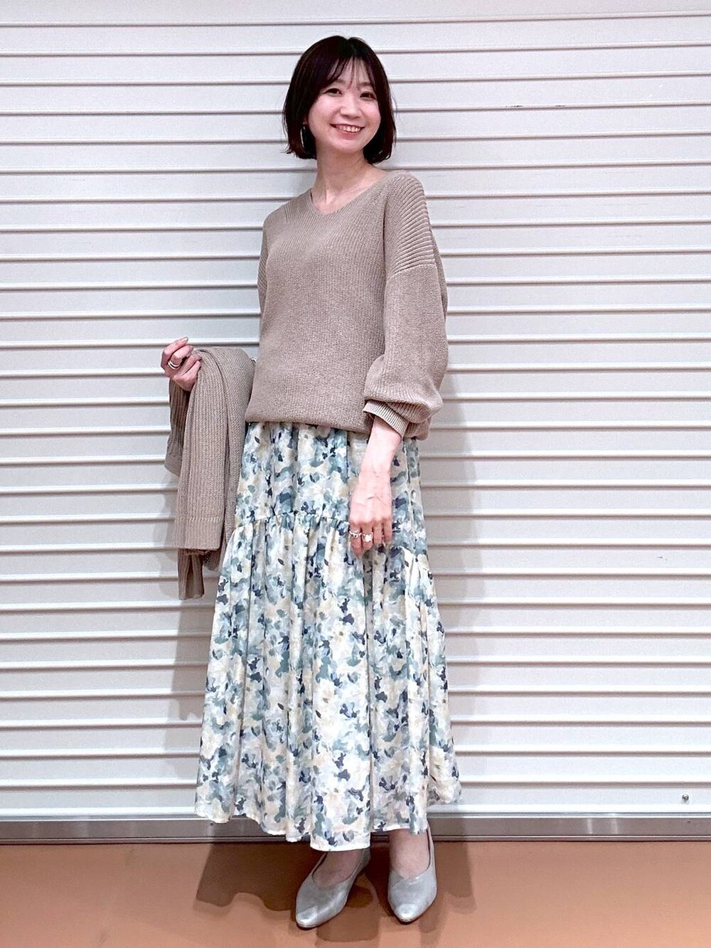 ベージュ系のニット/セーター、シルバー系のパンプス、ベージュ系のカーディガン/ボレロを着用したレディースの春コーディネートの2枚目の写真