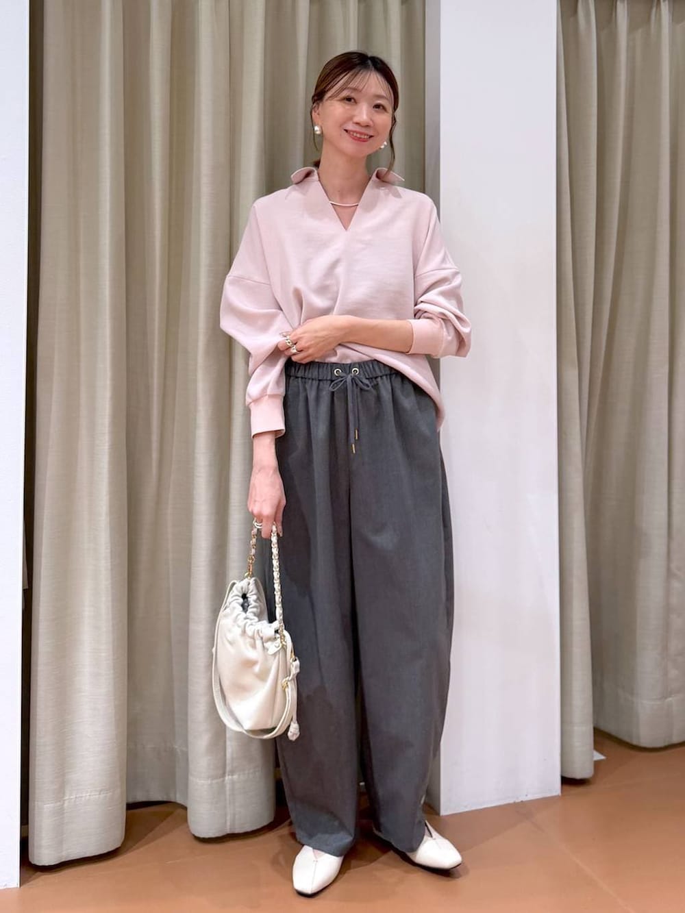 ホワイト系のハンドバッグ、ホワイト系のパンプス、グレー系のその他パンツを着用したレディースの冬コーディネートの6枚目の写真