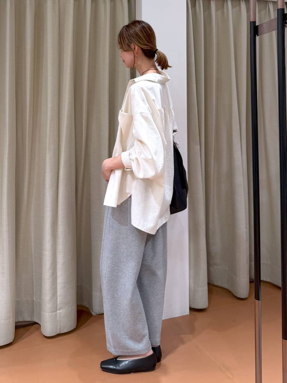 ブラック系のパンプス、グレー系のスウェットパンツ、ブラック系のトートバッグを着用したレディースの春コーディネートの3枚目の写真