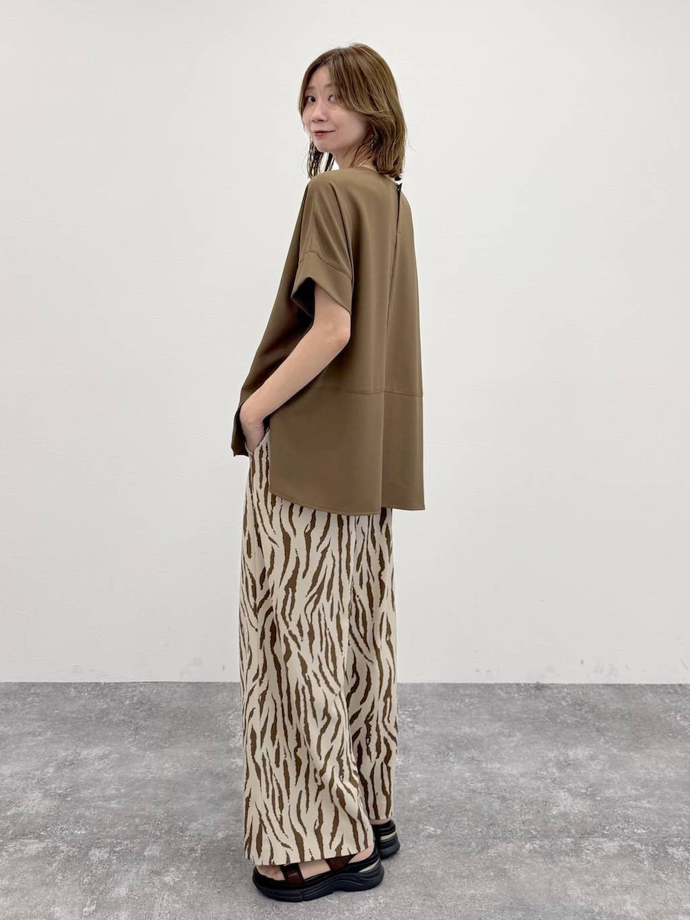 ゴールド系のトートバッグ、その他のその他パンツ、ブラウン系のTシャツ/カットソーを着用したレディースの春コーディネートの3枚目の写真