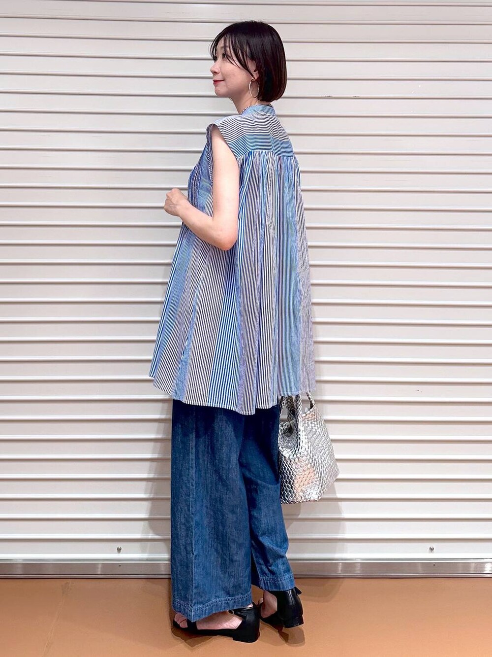 ブルー系のデニムパンツ、ブルー系のデニムパンツ、シルバー系のトートバッグを着用したレディースの夏コーディネートの3枚目の写真