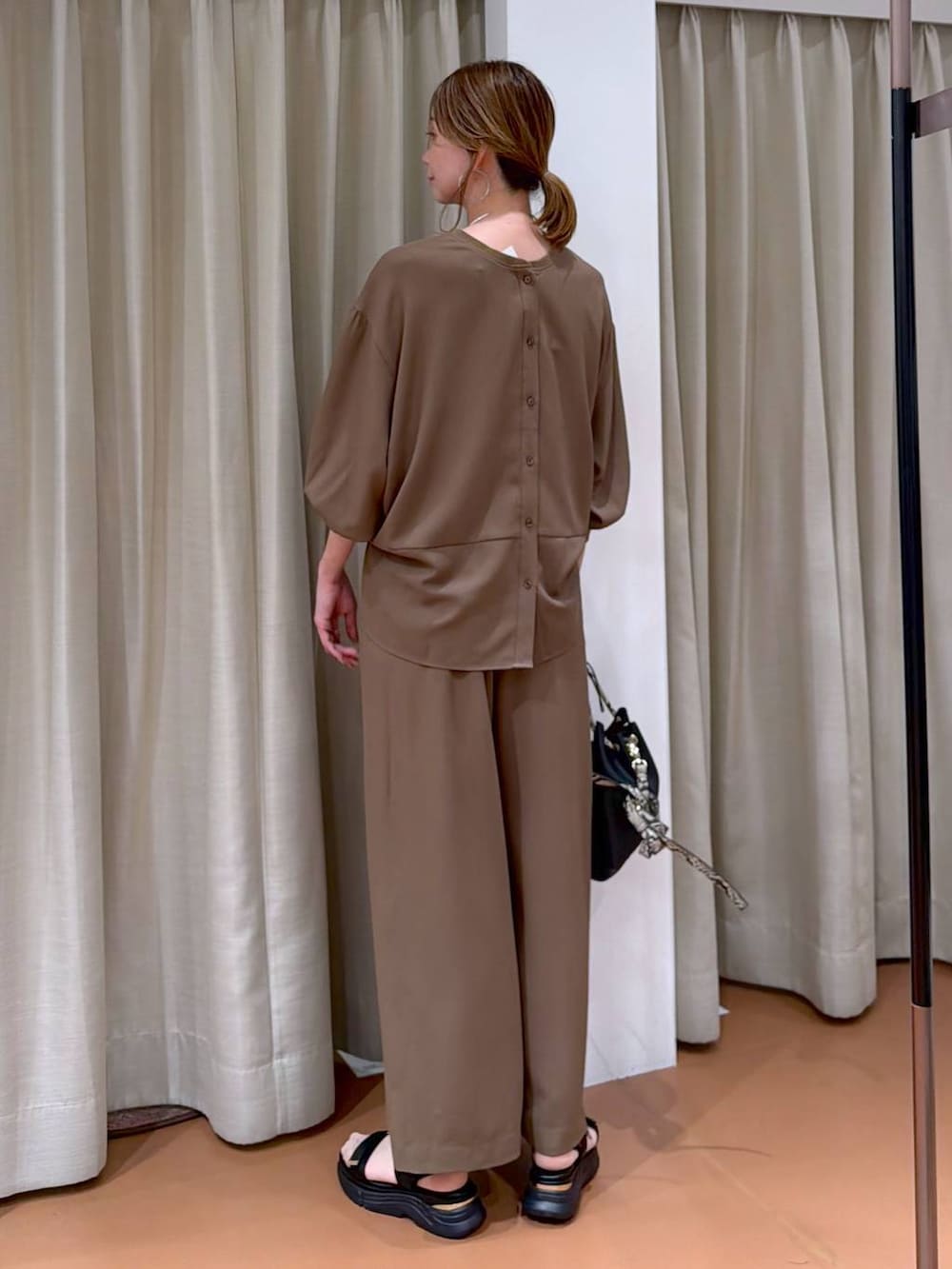 ブラック系のハンドバッグ、ブラウン系のその他パンツ、ブラウン系のシャツ/ブラウスを着用したレディースの春コーディネートの4枚目の写真