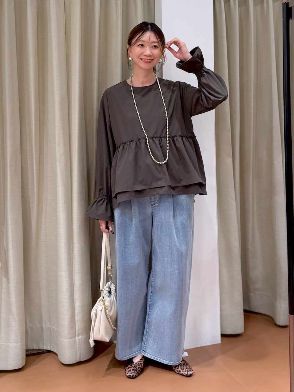 ホワイト系のハンドバッグ、ブルー系のデニムパンツ、ブラウン系のシャツ/ブラウスを着用したレディースの冬コーディネートの6枚目の写真