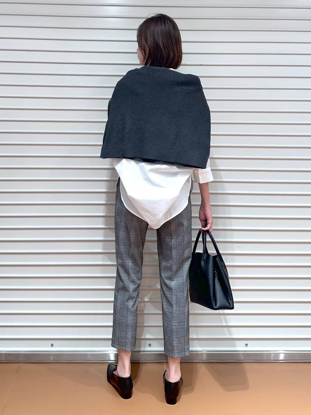 グレー系のニット/セーター、ブラック系のその他パンツ、ブラック系のハンドバッグを着用したレディースの秋コーディネートの4枚目の写真