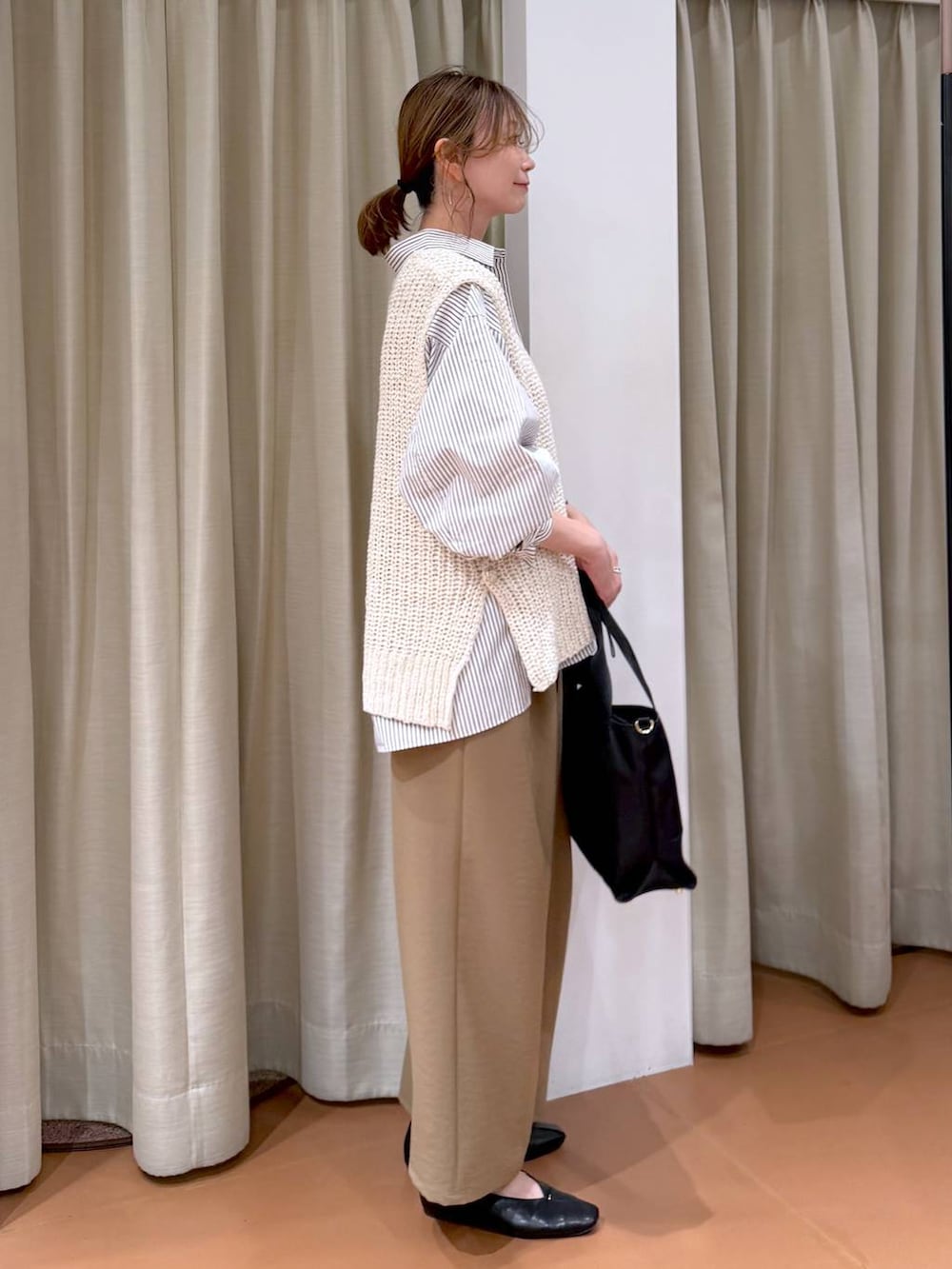 ブラック系のトートバッグ、ブラック系のパンプス、ブラウン系のシャツ/ブラウスを着用したレディースの春コーディネートの3枚目の写真