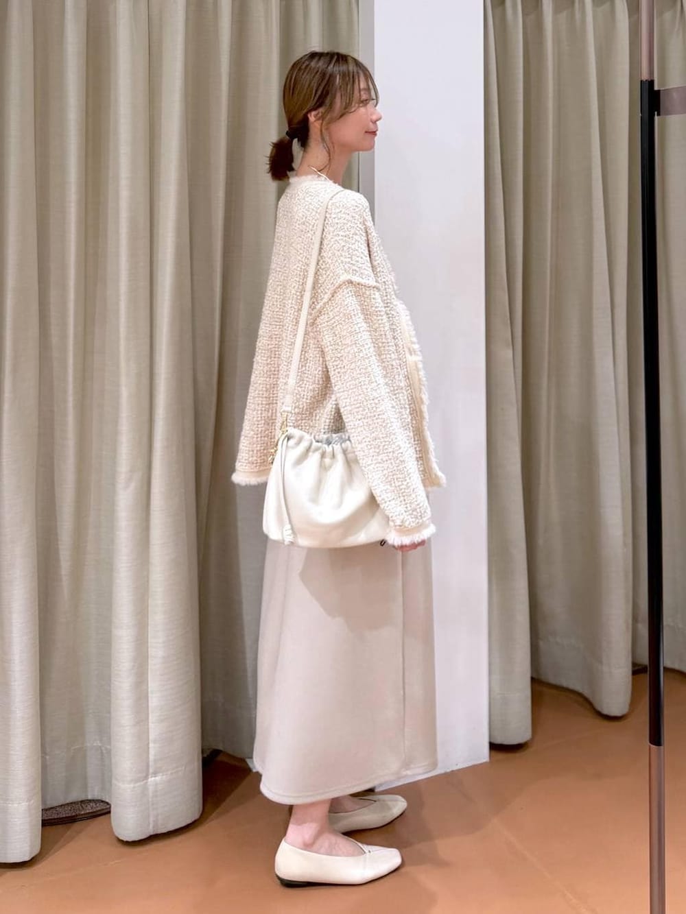 グレー系のTシャツ/カットソー、ホワイト系のハンドバッグ、ホワイト系のパンプスを着用したレディースの春コーディネートの5枚目の写真