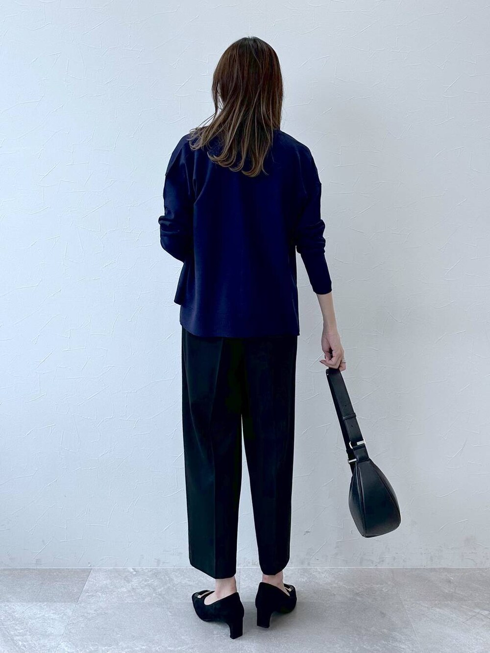 グレー系のパンプス、ブルー系のその他パンツ、ブラック系のハンドバッグを着用したレディースの冬コーディネートの4枚目の写真
