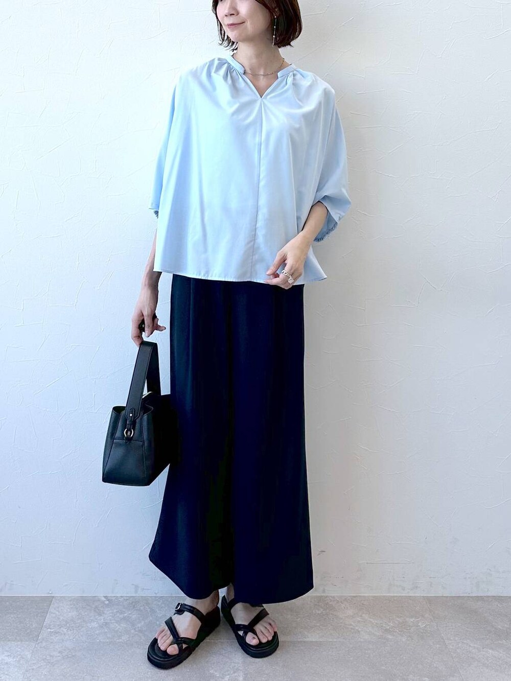 ブラック系のサンダル、ブルー系のシャツ/ブラウス、ブラック系のハンドバッグを着用したレディースの夏コーディネートの5枚目の写真
