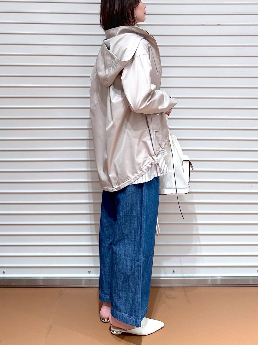 ブルー系のデニムパンツ、ホワイト系のシャツ/ブラウス、ベージュ系のマウンテンパーカーを着用したレディースの春コーディネートの8枚目の写真