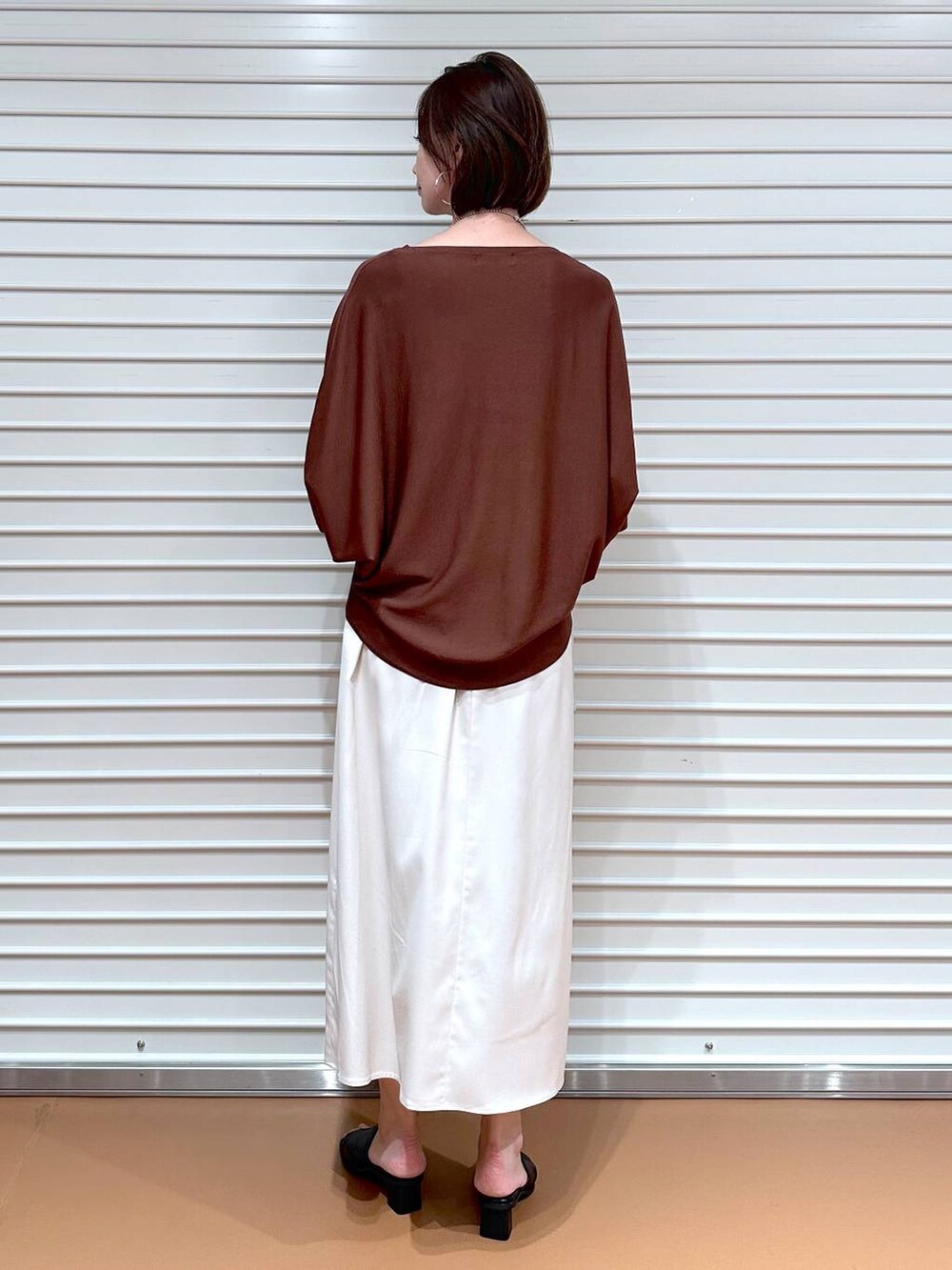 ブラック系のサンダル、ブラウン系のニット/セーター、グレー系のハンドバッグを着用したレディースの秋コーディネートの4枚目の写真