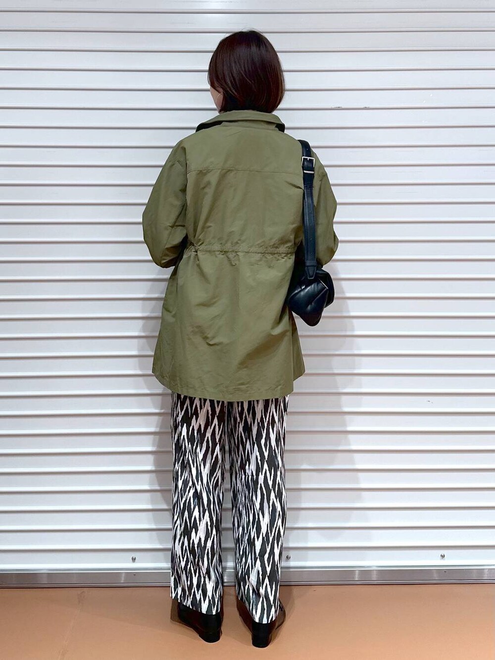 ブラック系のローファー、ホワイト系のTシャツ/カットソー、グリーン系のその他アウターを着用したレディースの秋コーディネートの4枚目の写真