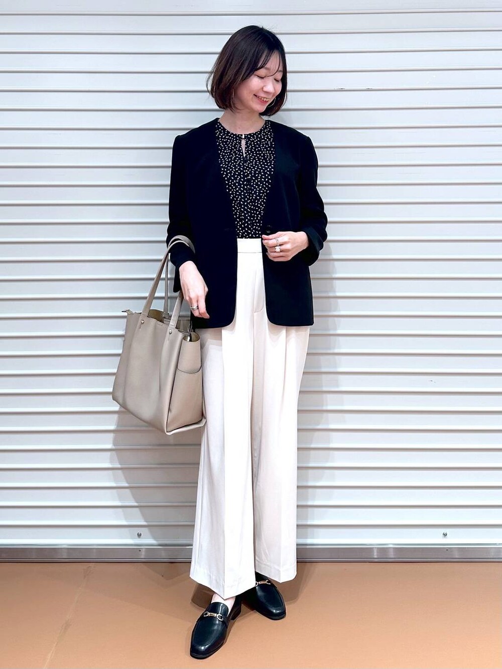 ブラック系のシャツ/ブラウス、ホワイト系のその他パンツ、ベージュ系のトートバッグを着用したレディースの春コーディネートの2枚目の写真