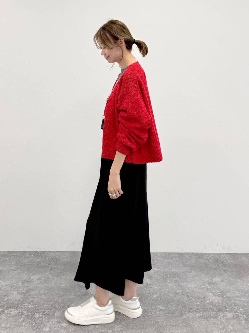 シルバー系のスニーカー、ブラック系のスカート、レッド系のカーディガン/ボレロを着用したレディースの春コーディネートの5枚目の写真