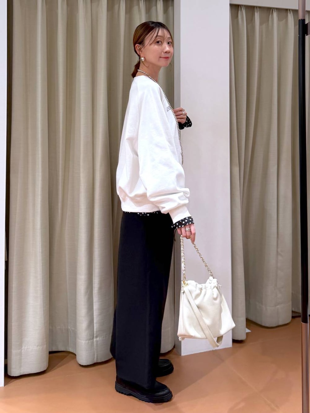 ホワイト系のハンドバッグ、ブラック系のローファー、ブラック系のシャツ/ブラウスを着用したレディースの冬コーディネートの3枚目の写真