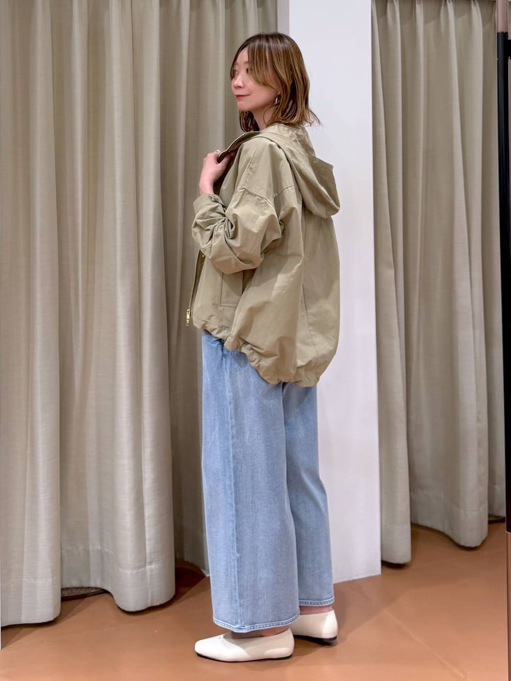 ホワイト系のパンプス、ブルー系のデニムパンツ、ホワイト系のハンドバッグを着用したレディースの春コーディネートの3枚目の写真