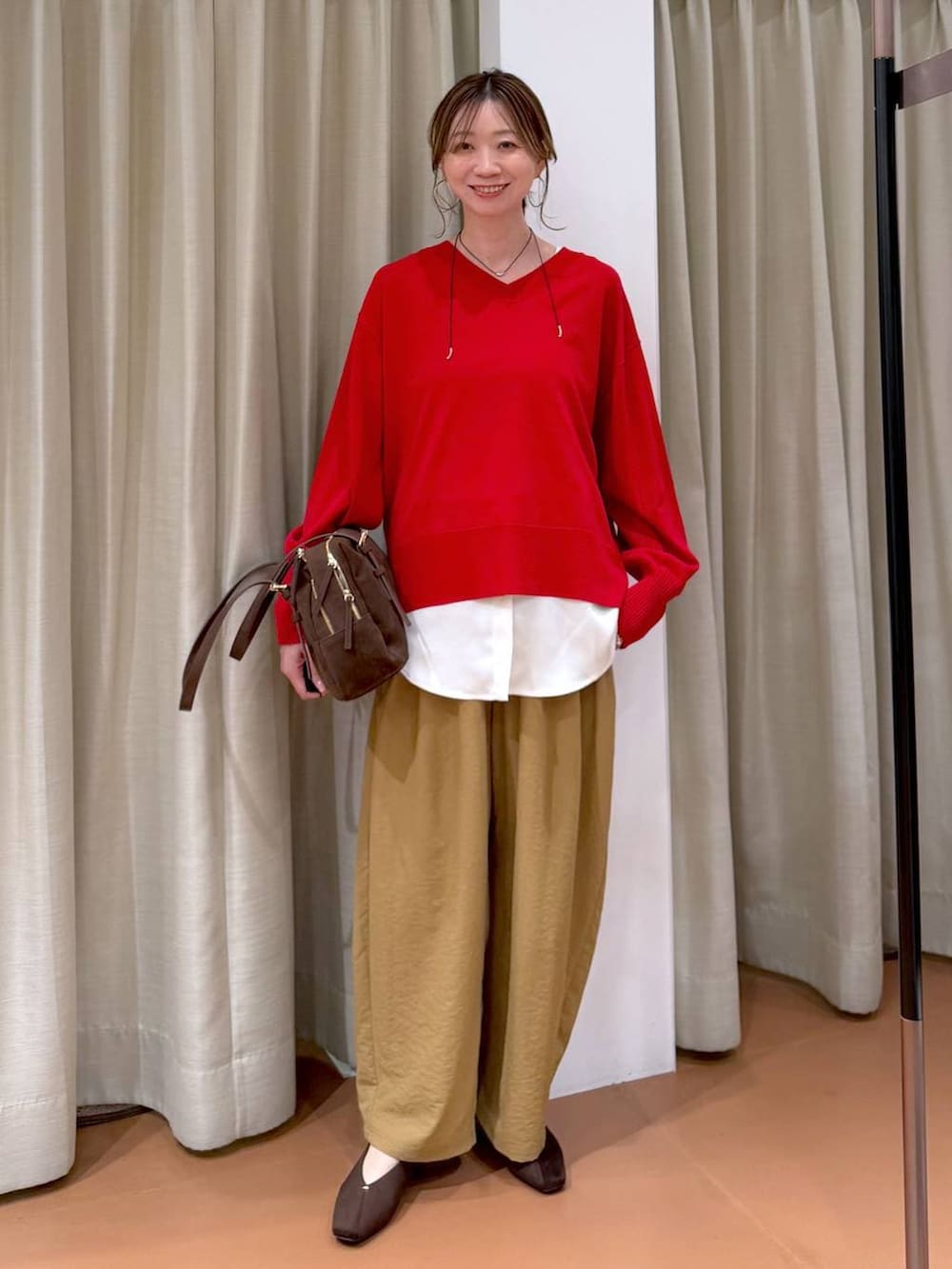 ブラウン系のパンプス、ブラウン系のボストンバッグ、イエロー系のその他パンツを着用したレディースの春コーディネートの6枚目の写真