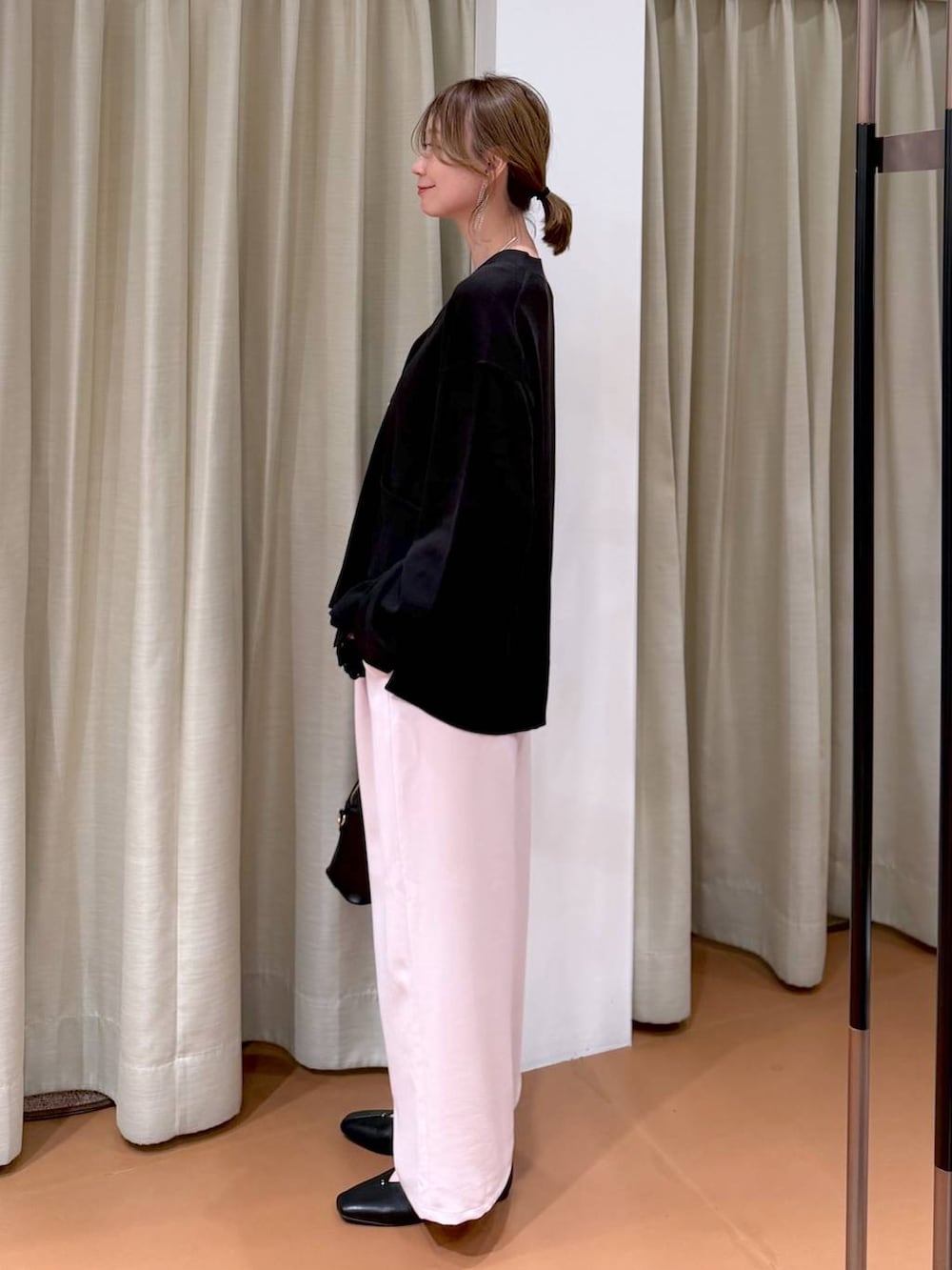 ブラック系のハンドバッグ、ブラック系のパンプス、ブラック系のタンクトップを着用したレディースの冬コーディネートの3枚目の写真