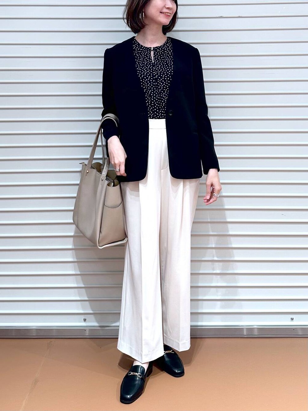 ブラック系のシャツ/ブラウス、ホワイト系のその他パンツ、ベージュ系のトートバッグを着用したレディースの春コーディネートの8枚目の写真