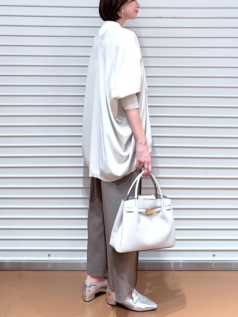 ブラウン系のその他パンツ、グレー系のカーディガン/ボレロ、グレー系のハンドバッグを着用したレディースの秋コーディネートの6枚目の写真