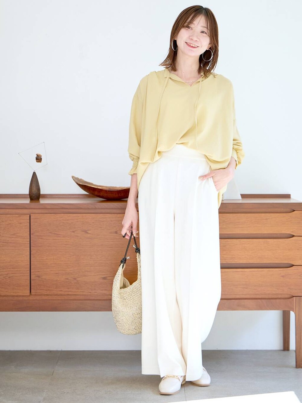 イエロー系のシャツ/ブラウス、ホワイト系のパンプスを着用したレディースの春コーディネートの2枚目の写真