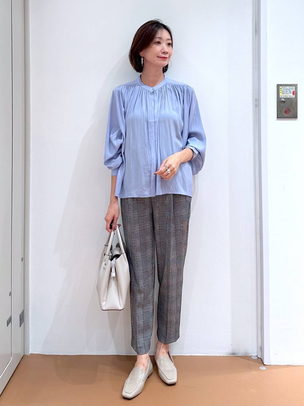 ブラック系のその他パンツ、グレー系のハンドバッグ、ブラウン系のパンプスを着用したレディースの秋コーディネートの2枚目の写真